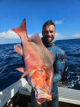 Load image into Gallery viewer, Man holding a large red fish on a boat with blue ocean and sky in the background