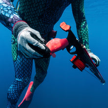 Load image into Gallery viewer, Person in a wetsuit holding Aimrite signature red Vendetta in clear blue water.