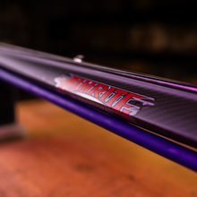 Load image into Gallery viewer, Close up view of aimrite logo sticker on aimrite vendetta roller speargun with purple bands