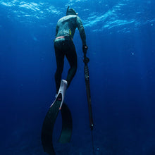 Load image into Gallery viewer, Person freediving underwater with a spear gun in clear blue water
