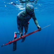 Load image into Gallery viewer, Diver wearing blue/green wetsuit in clear blue water holding aimrite Vendetta roller speargun
