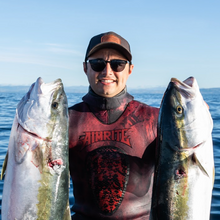 Load image into Gallery viewer, Diver wearing aimrite black trucker hat, holding fish out in ocean
